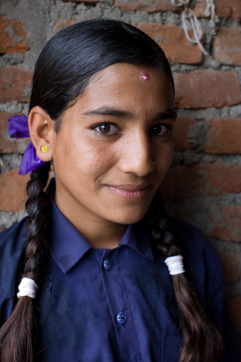 Girl in Nepal — A young girl poses outside her school in Nepal — Children, Nepal, student, students, girl