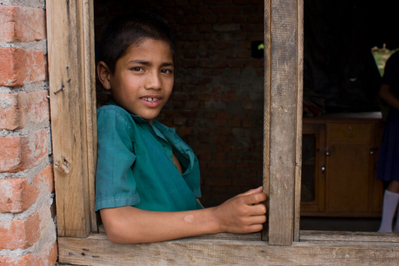 Girl in Window — Happy girl smiles out the window of her school in Nepal. — Children, Nepal, student, students, girl