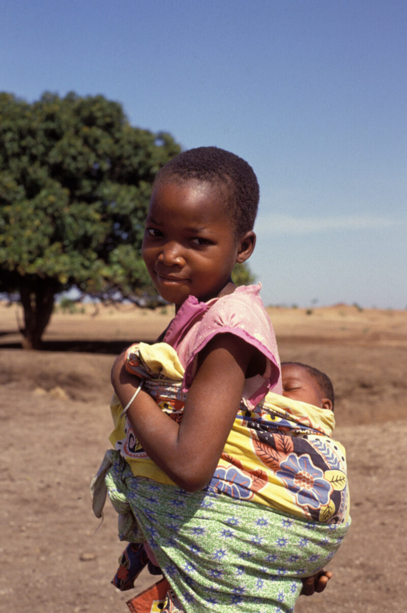 Girl and Baby in Malawi — Young girl in Malawi looks after her baby sister, slinging her on her back like her mother does. — Malawi, girl, baby, child, children