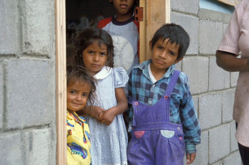 Internally Displaced in Honduras — Children from a village in Honduras that was wiped out by mudslides sit in front of their new homes build by ADRA — Hondur...