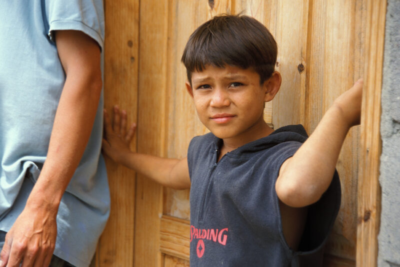 Internally Displaced in Honduras — Boy from a village in Honduras that was wiped out by mudslides stands in the doorway of his new home, built by ADRA — Hond...