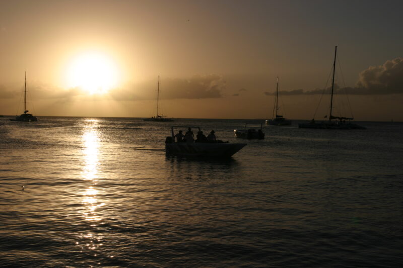 Sunset in the Dominican Republic — Boats and their drivers are silhouetted by the setting sun at a beach near La Romana, in the Dominican Republic — Dominica...