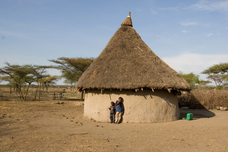 Brothers by thei home in Ethiopia — Stock Images of typical round mud huts of rural Ethiopia — Ethiopia, Africa, African, Africans, Ethiopian
