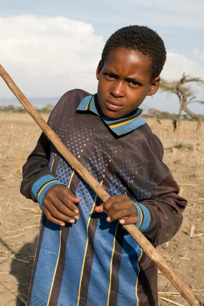 Disabled Boy in Ethiopia — Stock Image of boy with disability out in a field with a stick he uses to mind the family animals. — Ethiopia, Africa, African, Af...