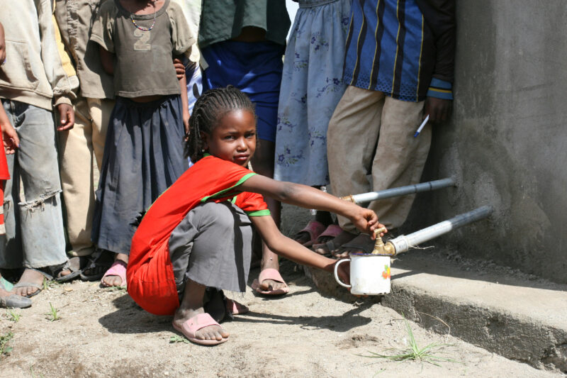Getting Water at School — Girl gets water from a tank at school that catches the reain water from the roof of the school. — Ethiopia, Africa, African, Africa...