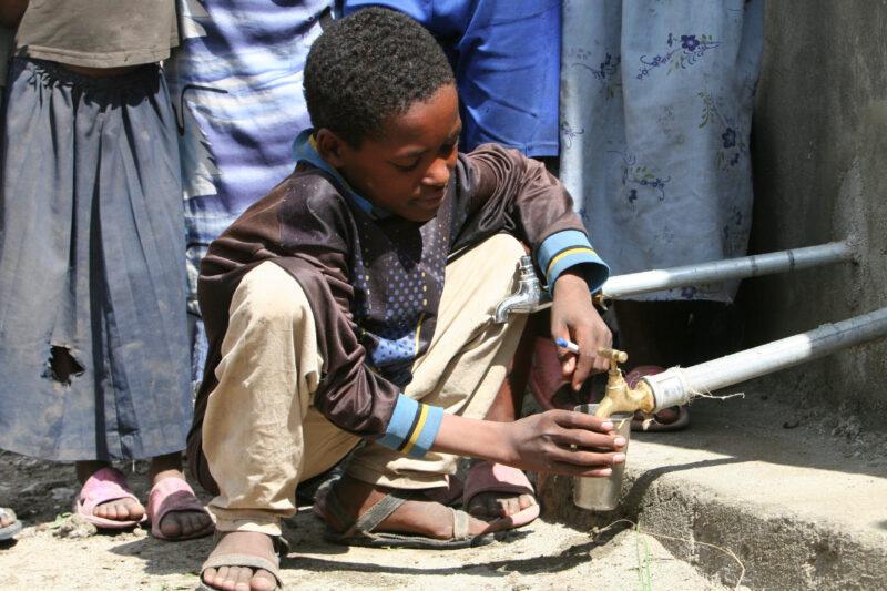 Boy Gets Drink at School — Students enjoy the convenience of water from a tap, outside their new school provided by ADRA Norway — Ethiopia, Africa, African, ...