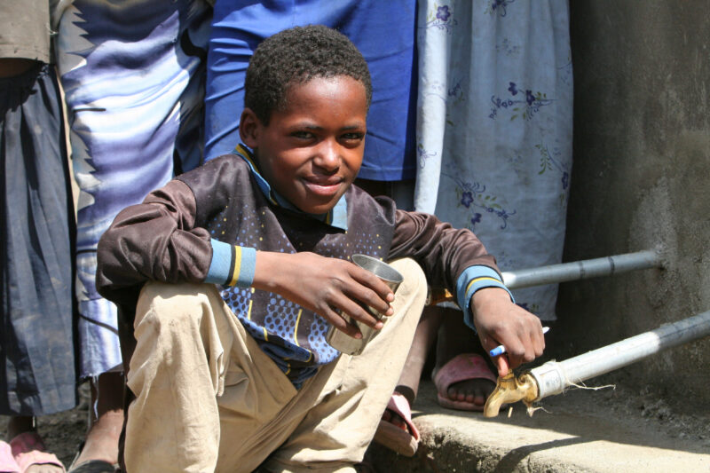 Boy Gets Drink at School — Students enjoy the convenience of water from a tap, outside their new school provided by ADRA Norway — Ethiopia, Africa, African, ...