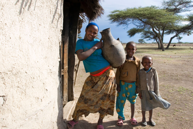 Children in Rural Africa — Poor children of Ethiopia stand outside the doorway to their mud hut, with water container — Ethiopia, Africa, African, Africans, ...