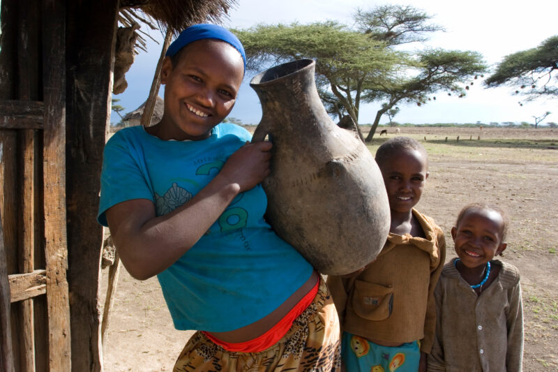 Children in Rural Africa — Poor children of Ethiopia stand outside the doorway to their mud hut, with water container — Ethiopia, Africa, African, Africans, ...