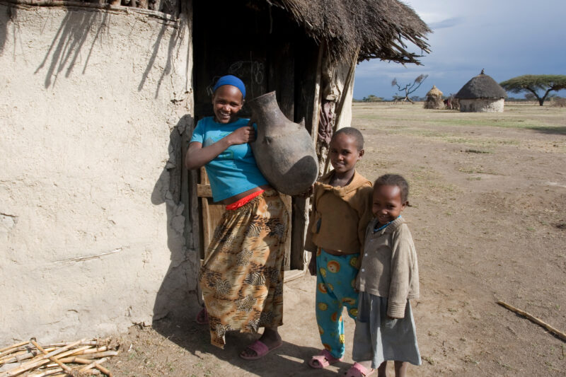 Children in Rural Africa — Poor children of Ethiopia stand outside the doorway to their mud hut, with water container — Ethiopia, Africa, African, Africans, ...