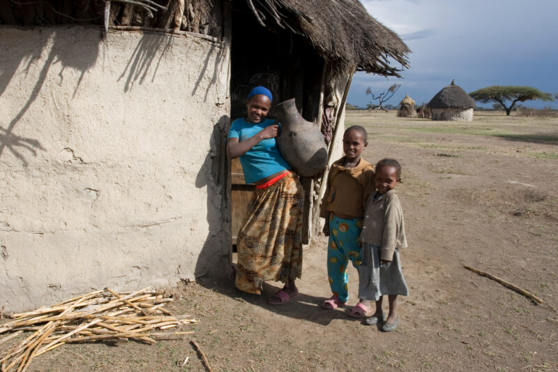 Children in Rural Africa — Poor children of Ethiopia stand outside the doorway to their mud hut, with water container — Ethiopia, Africa, African, Africans, ...