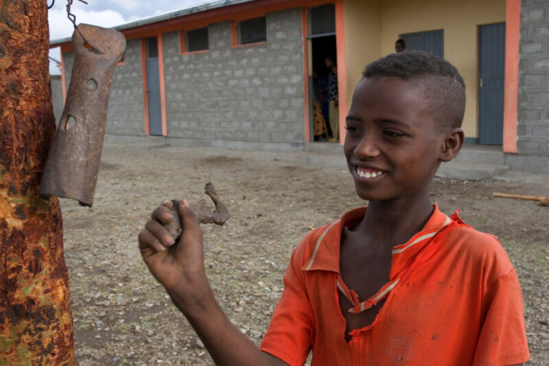 Boy in Ethiopia Rings the School Bell — Stock image of a boy growing up in poverty in rural Ethiopia, Africa — Ethiopia, Africa, African, Africans, Ethiopian