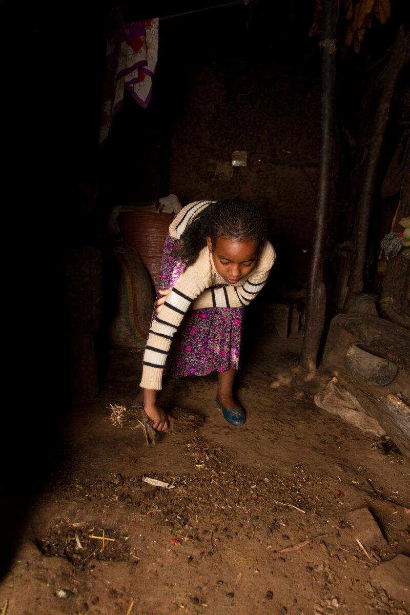 Sweeping Dirt Floor in Ethiopia — Girl cleans her home in Ethiopia sweeping the dirt floor. — Ethiopia, Africa, African, Africans, Ethiopian