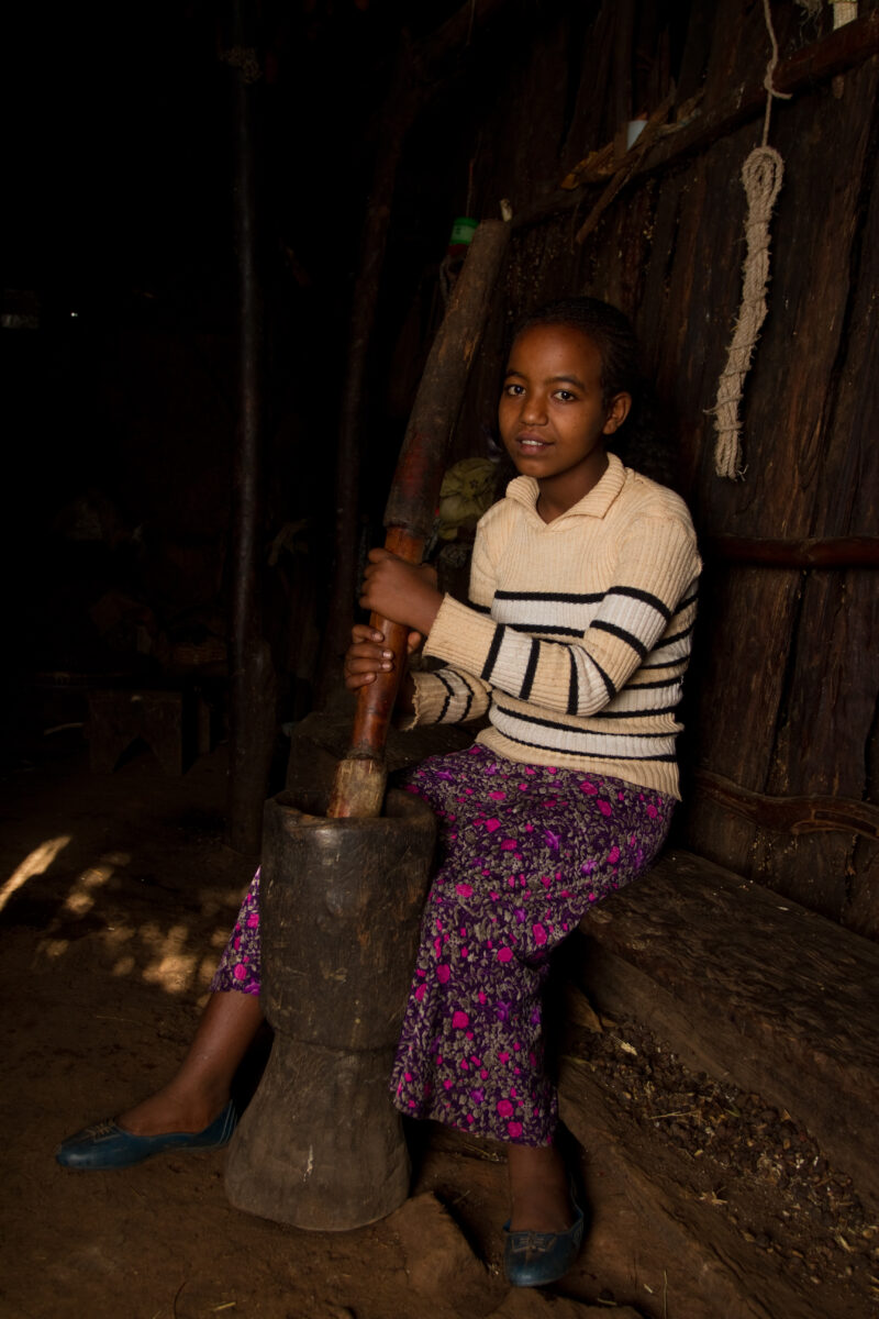Pounding Grain in Ethiopia — Young girl pounds maize into flour in her home in Ethiopia — Ethiopia, Africa, African, Africans, Ethiopian