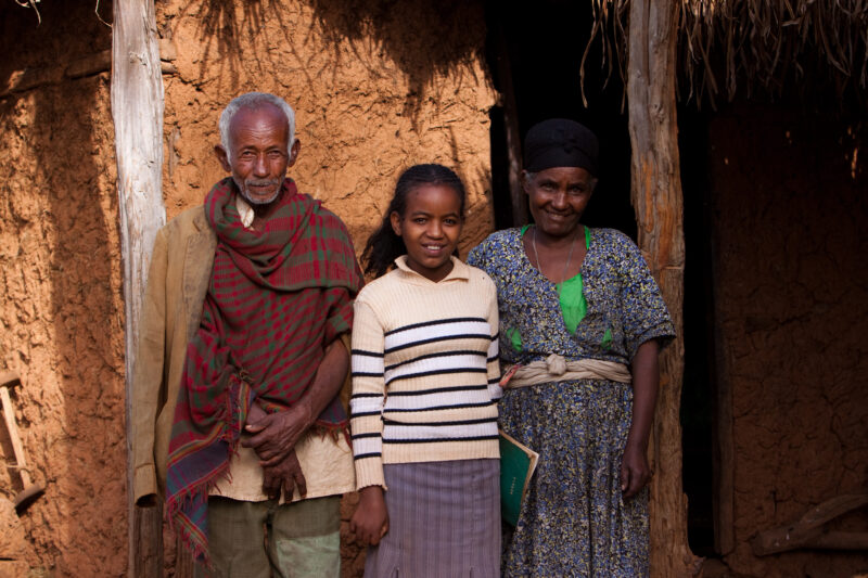 Girl with her Parents in Ethiopia — Stock Image of girl with her parents in front of their home before she leaves for school — Ethiopia, Africa, African, Afr...