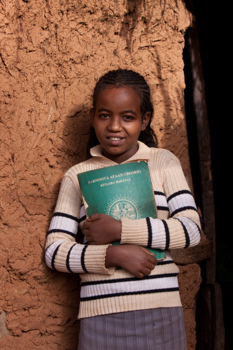Ready for School in Ethiopia — Young girl in Ethiopia stands by her home with her school books, ready to go to school — Ethiopia, Africa, African, Africans, ...