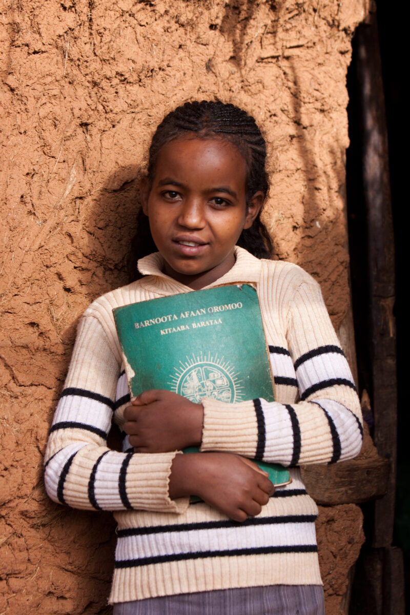 Ready for School in Ethiopia — Young girl in Ethiopia stands by her home with her school books, ready to go to school — Ethiopia, Africa, African, Africans, ...