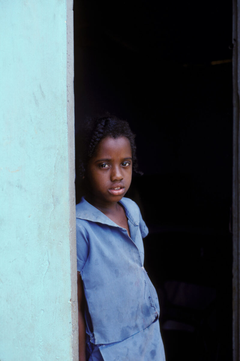 Girl in Jamaica — Young girl stands in the doorway of her poor home in Jamaica — Children, faces, child, girls, Jamaica
