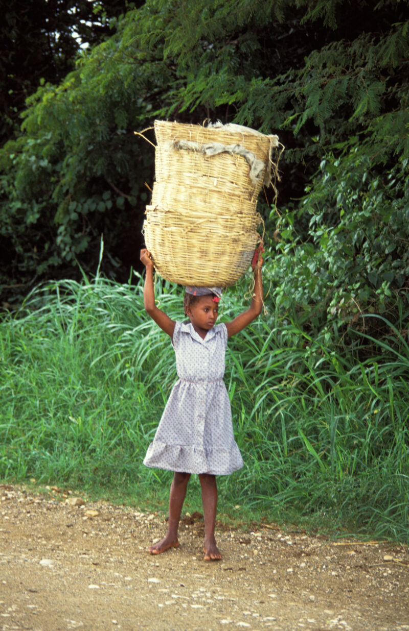 Stock Images of Haiti — Young girl with baskets on head, heads out to do wash — Haiti, Caribbean, poor, poverty, child