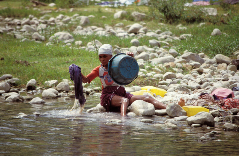 Stock Images of Haiti — Woman Washes Clothes in River — Haiti, Caribbean, Poverty, wash, laundry