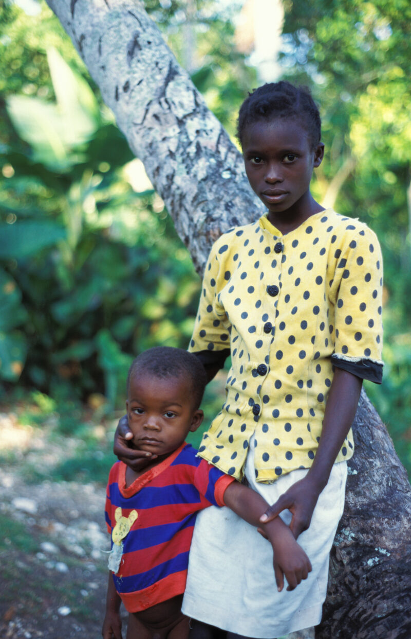 Stock Images of Haiti — Stock Image of Haiti: Girl in Haiti with Baby Brother by Tree — Haiti, Haitian, girl, girls, baby