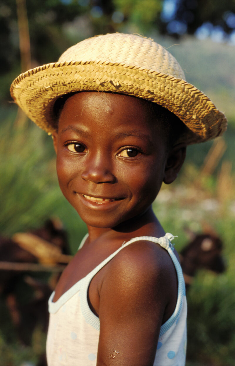 Stock Images of Haiti — Stock Image of Haiti: Smiling boy in the morning light with straw hat and t shirt — Haiti, Haitian, boy, boys, smiles