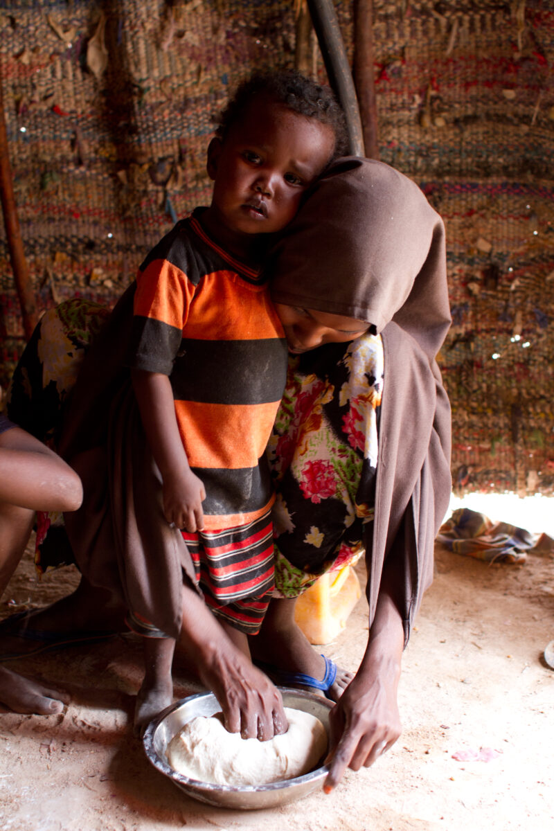 A Time of Drought in Somolia — Woman makes bread with flour she has received at a Emergency food distribution. — Somolia, IDP, Internally Displaced, drought,...