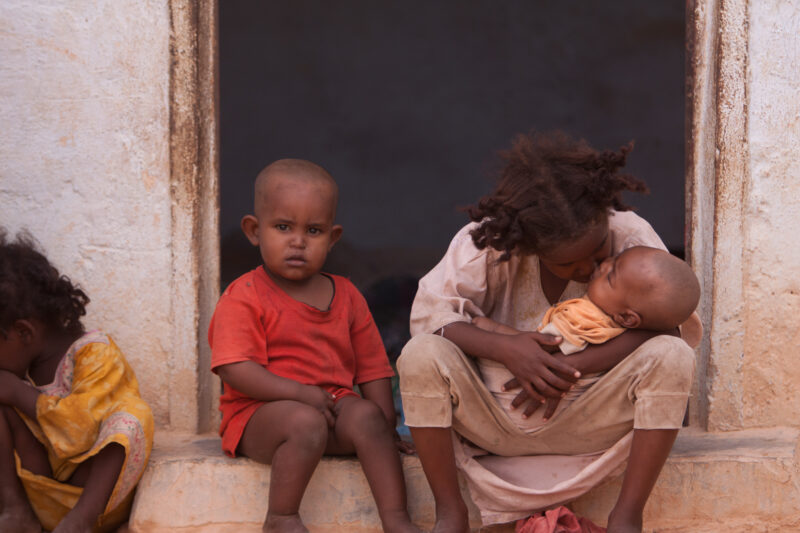 A Time of Drought in Somolia — Girl kisses her baby brother in a doorway in Somalia — Somolia, drought, IDP, Internally Displaced