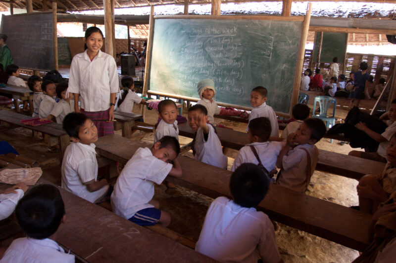 Teaching Class — Teacher at a blackboard, at the Karen Adventist Academy, teaching children at a Karen refugee camp in Thailand. — Thailand, Karen, Refugee, ...