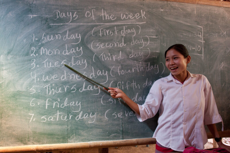 Teaching Class — Teacher at a blackboard, at the Karen Adventist Academy, teaching children at a Karen refugee camp in Thailand. — Thailand, Karen, Refugee, ...