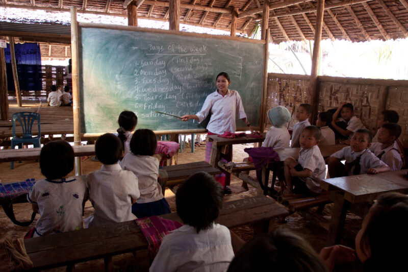 Teaching Class — Teacher at a blackboard, at the Karen Adventist Academy, teaching children at a Karen refugee camp in Thailand. — Thailand, Karen, Refugee, ...
