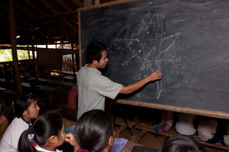 Teaching Class — Teacher at a blackboard, at the Karen Adventist Academy, teaching children at a Karen refugee camp in Thailand. — Thailand, Karen, Refugee, ...