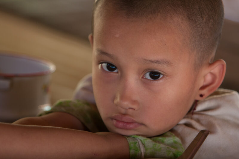 Getting a Hot Meal at School — Children eat a bowl of hot soup, as part of their school feeding program, at a Karen refugee camp, near the Thai border with M...