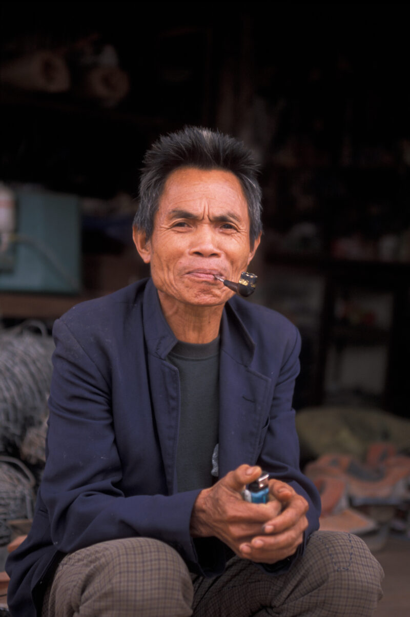 Man in Laos — Man smokes pipe at his shop in Laos — Laos, Southeast Asia, man, men, smoking