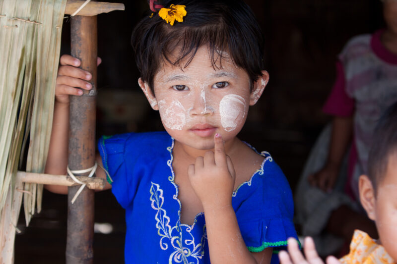 Girl in Burma — Girl with tanaka on face, in the doorway of her bamboo house in Burma — Burma, Myanmar, girl, girls, tanaka