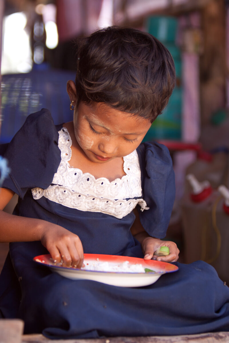 Girl Eats Rations in Burma — Girl eats rice from a emergency food distribution of ADRA in the Irrawaddy Delta region of Myanmar, after Cyclone Nargis destroy...