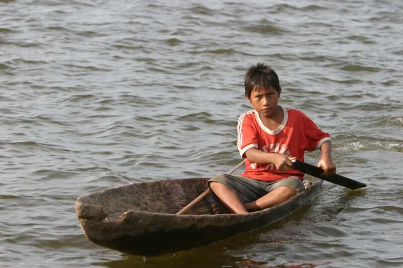 Boy in Dugout — Boy paddles in his dugout canoe — ADRA, Peru, Poverty, Shipibo Indians, Ucayali River