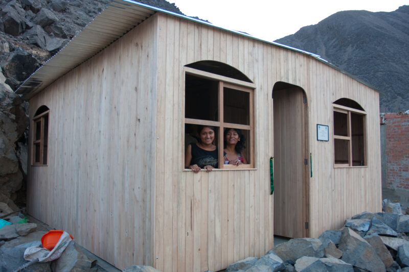 New House — Mother and daughter look out of their new home, provided by ADRA — Peru, house, ADRA