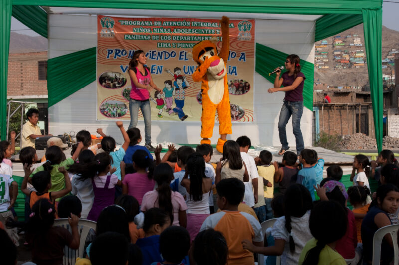 Teaching Social and Life Skills — Using songs and skits, at a rally set up in a poor community near Lima, teaches children and parents life skills — Peru, AD...