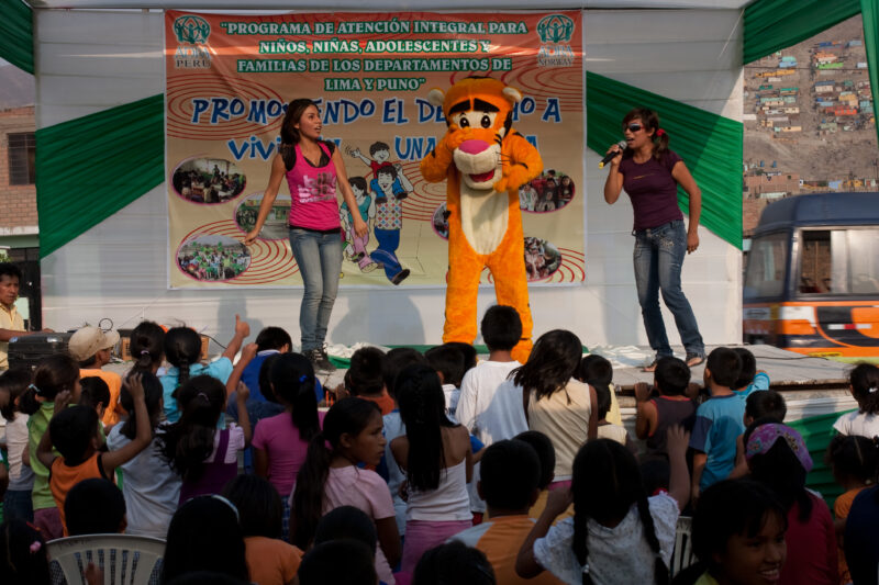 Teaching Social and Life Skills — Using songs and skits, at a rally set up in a poor community near Lima, teaches children and parents life skills — Peru, AD...