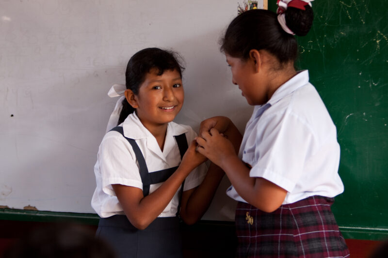 Student in Peru — Profile of a mother and her two children living in one of the poor communities on the outskirts of Lima, Peru: girl tells her friend about ...