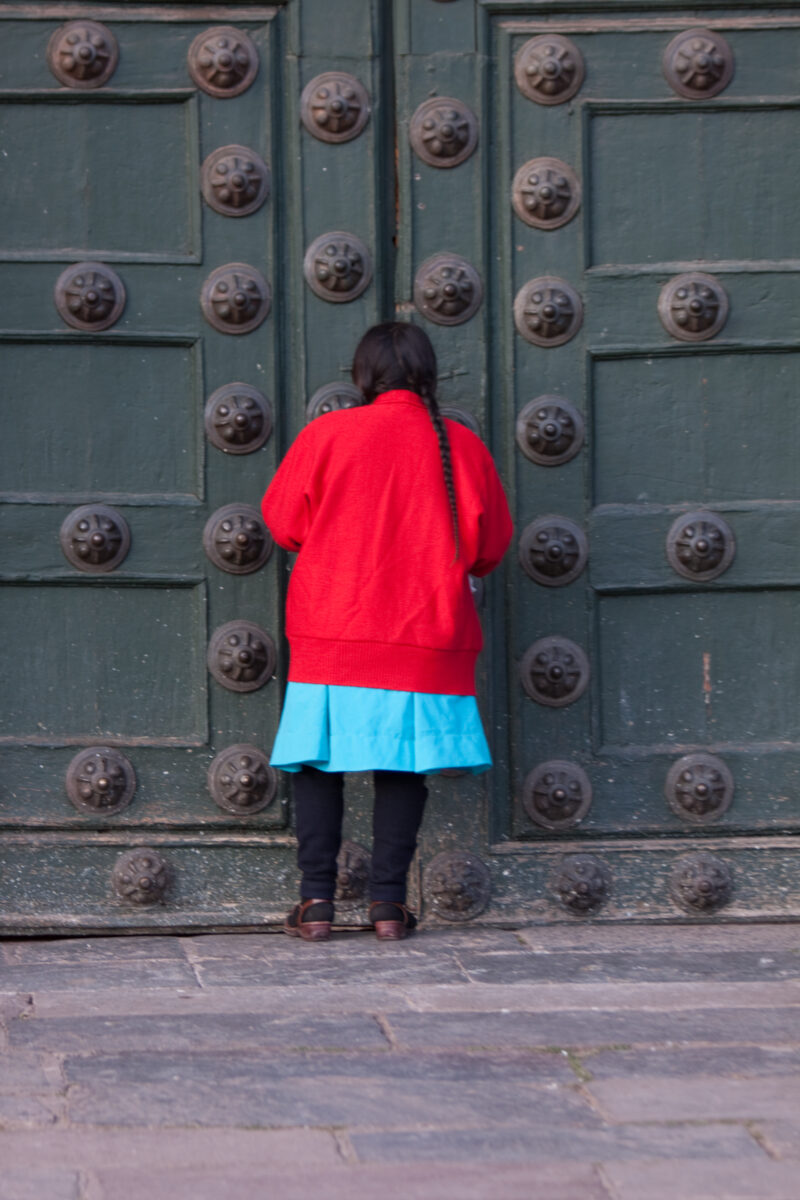 Prayer at the Doors of the Church — Peuvian woman prays by the huge doors of a catholic church in Cusco — Peru, woman, prayer, door, doors
