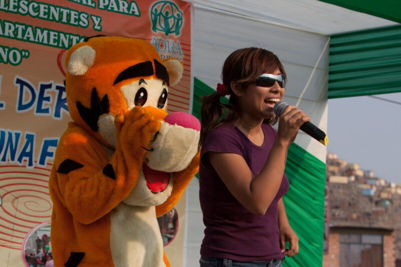Teaching Social and Life Skills — Using songs and skits, at a rally set up in a poor community near Lima, teaches children and parents life skills — Peru, AD...