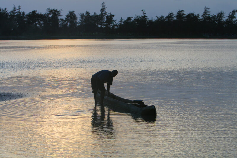 Man in Canoe in evening light — Togo, Africa, West Africa