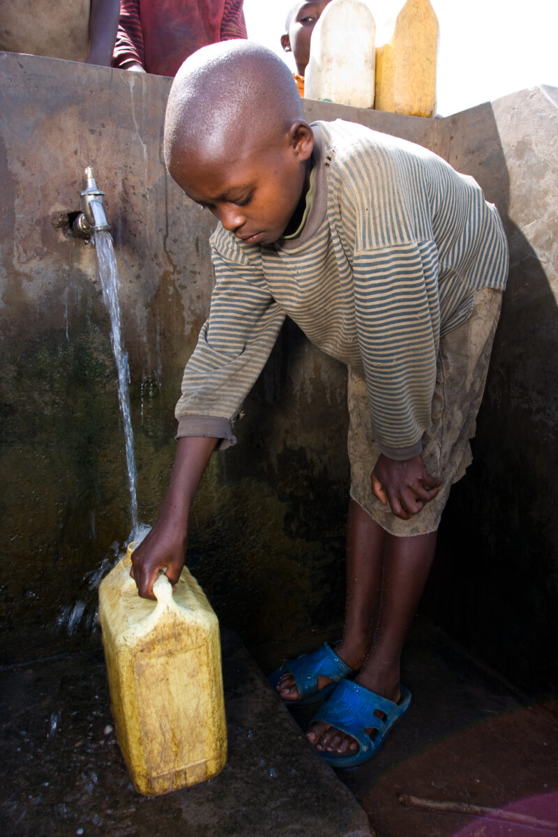 Collecting Water — Girl gets water from a gravity fed water system installed by ADRA. — Africa, Rwanda, girl, collecting water, water system