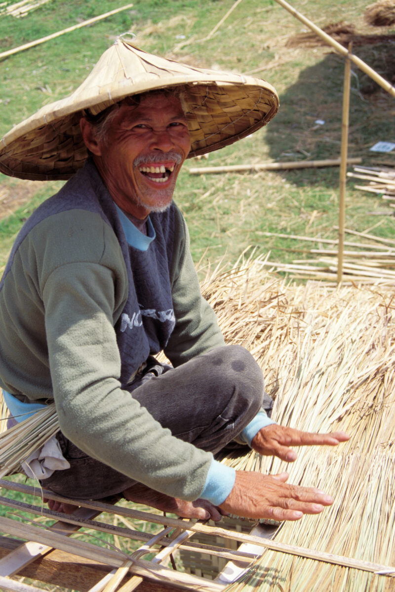 Elder Man in the Philippines — Elderly man of the Philippines, works on the roof of a bamboo house. — Philippines, woman, elder, elderly, man