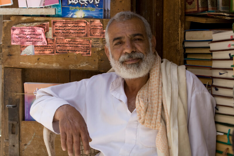Man Sells Books in the Market — Elderly man in the market of the Old City of Sana, Yemen. — Yemen, people, men, faces, man
