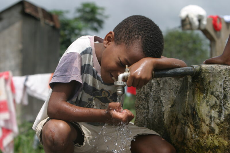 Boy gets a Drink — Boy gets a refreshing drink from a gravety fed water system that has been installed in his village. — Sao Tome, Africa, boy, child, children