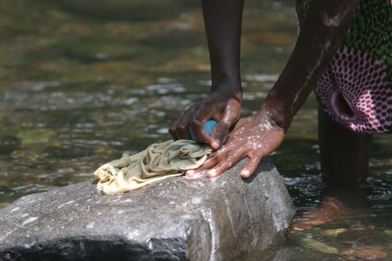 Wash Day in Sao Tome — Stock photos of women washing clothes by hand in a river near their village, in Sao Tome, Africa — Sao Tome, Africa, washing, clothes,...