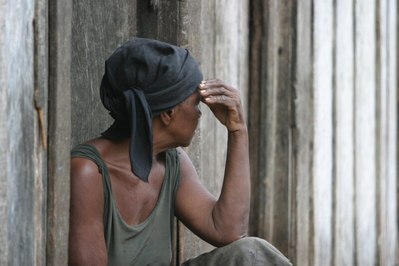 Poverty in Sao Tome — Woman sits in doorway of her poor home, with sadness and depression, in Sau Tome, Africa — Sao Tome, Africa, woman, sadness, depression
